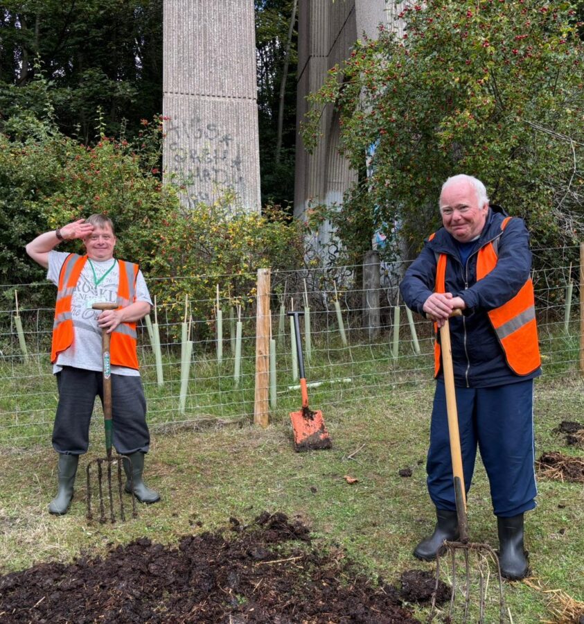 Two men in a field with tools